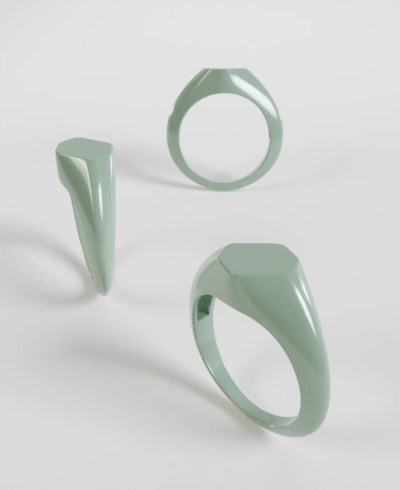 3D render of a pastel green signet ring, featuring an elongated hexagonal flat face set diagonally across the band, shown from multiple angles.