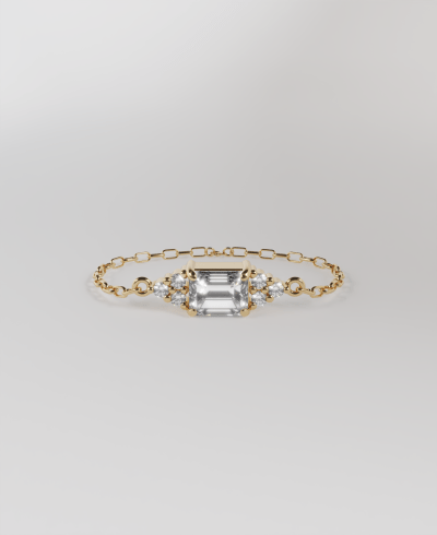 18k yellow gold chain bracelet featuring a horizontal pendant emerald cut clear diamond, with round clear diamonds 3 at the top and three at the bottom, on a delicate gold chain band.