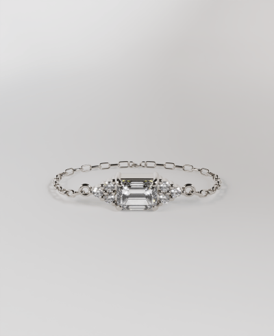 18k white gold chain bracelet featuring a horizontal pendant emerald cut clear diamond, with round clear diamonds 3 at the top and three at the bottom, on a delicate gold chain band.